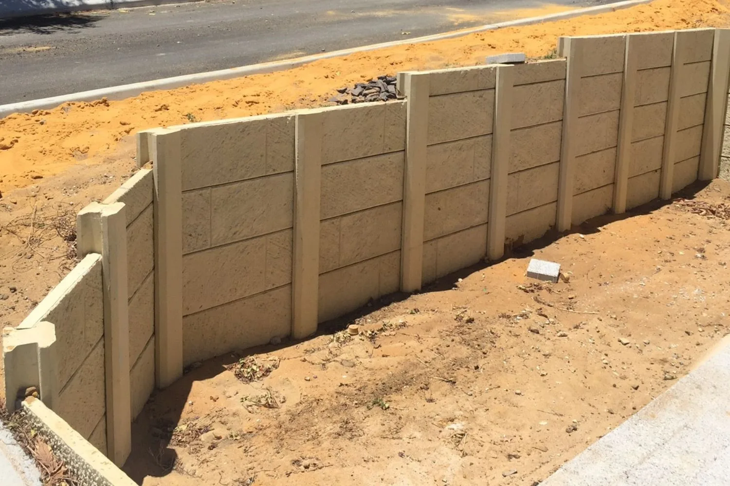 Modern precast concrete panel retaining wall with landscaped garden bed above